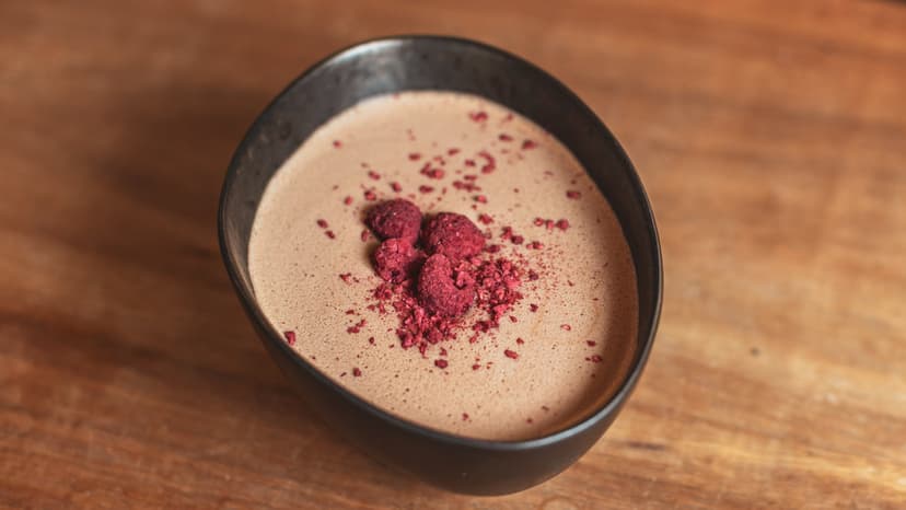 A cup of Kakaw dusted with crushed raspberry
